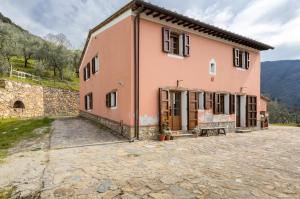 卡尔奇Olive House Tuscany的一座大型粉红色房子,设有石头庭院