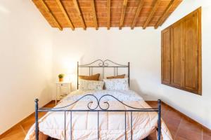 卡尔奇Olive House Tuscany的卧室内的一张床铺,设有木制天花板