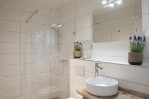 让贝克Hegyalja Étterem és Panzió的白色的浴室设有水槽和淋浴。