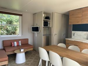 阿雷斯Mobil home PREMIUM 35m2 3 chambres 6 personnes的一间带餐桌的客厅和一间厨房