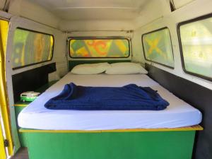 韦尔卡鲍Kombi Hostel Camping的拖车后面的一张带两个窗户的床