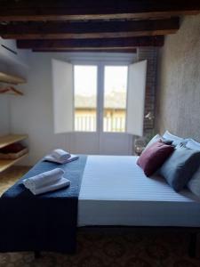 维克FeelhomeVIC. Ático con terraza en centro histórico的卧室配有带枕头的床铺和窗户。