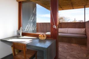 圣佩德罗·德·阿塔卡马Tierra Atacama的客房设有桌子、椅子和窗户。