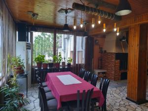 BrestnikКъща за гости Вишнева градина的用餐室配有粉红色的桌子和椅子