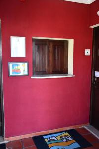 米尔芳提斯城Alojamentos Vitinho - Vila Nova Milfontes的室内的红色墙和橱柜