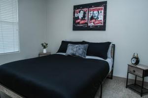 拉斯维加斯Beautiful TownHome With Garage in Las Vegas的卧室配有一张黑色床,墙上挂着时钟