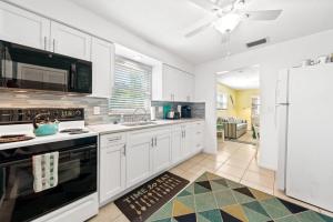 克利尔沃特Beach Villa A的厨房配有白色橱柜和白色冰箱。