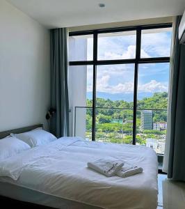 哥打京那巴鲁Summer Studio Apartment at Kota Kinabalu City Centre的一间卧室设有一张大床和大窗户