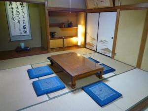 松江市GuestHouse AZMO - Vacation STAY 22715v的客厅配有桌子和4个蓝色垫子
