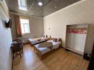 希瓦Polvon Ota Hotel的卧室配有一张床和一张桌子