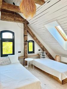 UblikUblik Stacja的客房设有两张床铺、木制天花板和窗户。