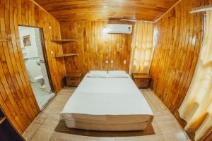 奥林波斯Kadir's Family House的木制客房内的一间卧室,配有一张床