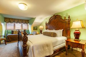 纽波特常青藤小屋酒店的一间卧室配有一张大床和一张桌子