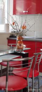 尤尔马拉Varnukroga House的一张桌子,上面有红色的椅子和橘子花瓶