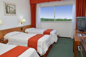 科洛尼亚-德尔萨克拉门托埃尔米拉多尔水疗酒店的酒店客房设有三张床和电视。