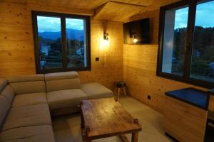 伊帕尼Le chamois, chez le charpentier d'antan, au calme, spacieux T3 duplex, ambiance chalet, vue dégagée, parking privé的带沙发、桌子和窗户的客厅