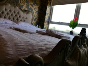 罗瑟勒姆Ultra Deluxe Versace Apartment Near Sheffield FULL SKY TV的卧室配有白色的床,窗户上放着鲜花