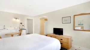 卢嫩堡侯姆珀特汽车旅馆的一间带白色床的卧室和一间厨房