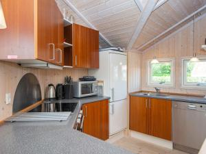 法伦6 person holiday home in Hemmet的厨房配有木制橱柜和白色冰箱。