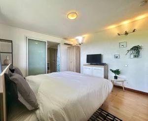 MarigotView apartment - St Barts的卧室配有一张白色大床和电视。