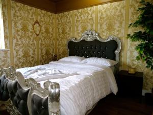罗瑟勒姆Stunningly Opulent Gold Apartment Near Sheffield FULL SKY TV的一间卧室配有一张带白色床单和金色壁纸的大床