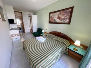 奥特朗托Hotel Minerva的一间卧室配有一张床和一把绿色椅子
