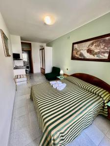 奥特朗托Hotel Minerva的一间卧室配有一张带条纹毯子的大床