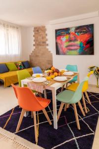 瓦伦西亚Grand Villa的客厅配有桌子和五颜六色的椅子