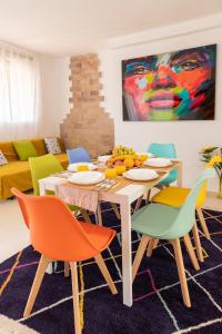 瓦伦西亚Grand Villa的一间配备有桌子和五颜六色椅子的用餐室
