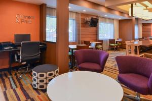 橘园杰克逊橙园费尔菲尔德客栈的一间设有白色桌子和紫色椅子的等候室