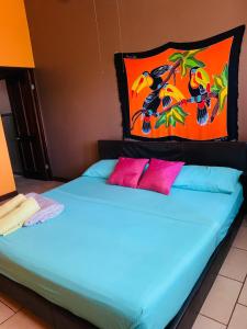 阿拉胡埃拉Around Juan Santa María的一张蓝色的床和两个粉红色枕头