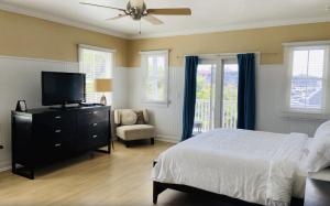 新肖雷汉姆Ballard's Beach Resort的一间卧室配有一张床、一台电视和一把椅子