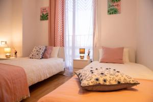 瓦伦西亚Grand Villa的一间卧室设有两张床和窗户。