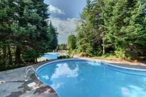蒙特朗布朗Serenity Peaks Lodge by InstantSuites-LaBete Golf的一座树木繁茂的庭院内的游泳池