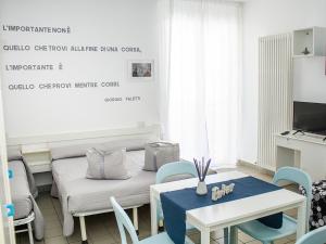 里乔内Residenza Clelia Riccione的客厅配有桌子和沙发