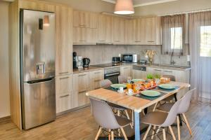锡蒂亚Sitia Bay View Villa Apartment的厨房配有木桌和不锈钢冰箱。