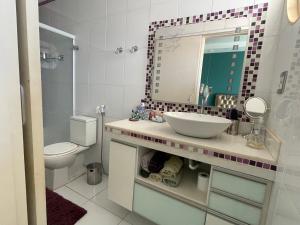 里贝朗普雷托Apart. centro Ribeirão Hospital São Lucas的一间带水槽、镜子和卫生间的浴室