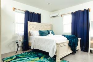 巴斯特尔La Vue de Basseterre Apartments - Luxury in Bird Rock的一间卧室配有蓝色窗帘的床