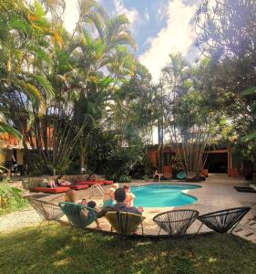 圣何塞哥斯达黎加背包客旅馆的一群人坐在游泳池边的椅子上