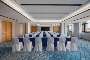 丹阳丹阳万枫酒店的一间会议室,配有蓝色的桌子和白色的椅子