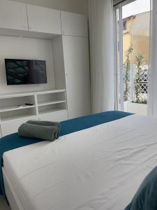 托里格兰德Windsurf Beach Front的卧室配有白色的床和电视