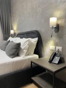 圣金Domus Hotel & Apartments的一间卧室配有一张带电话和一张桌子的床