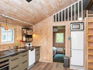海默特4 person holiday home in Hemmet的厨房设有木墙和冰箱。