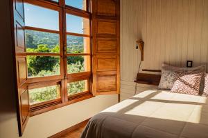 本图贡萨尔维斯Casarão do Vale dos Vinhedos的一间卧室设有一张床和一个大窗户