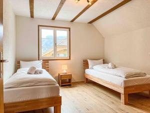 坎德施泰格Alpine Chalet的一间卧室设有两张床和窗户。