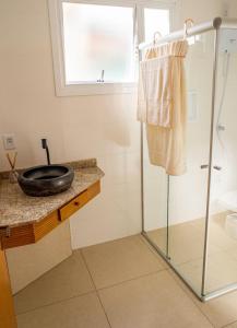 本图贡萨尔维斯Casa di legno italiana的一间带玻璃淋浴和水槽的浴室