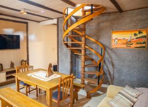 本图贡萨尔维斯Casa di legno italiana的客厅里设有木制螺旋楼梯和桌子