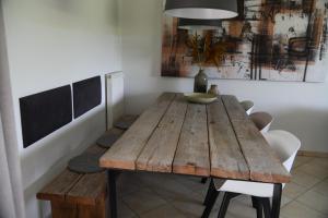 奥斯特豪特Boshuis Golfzicht "Wellness, Golf & Nature"的一间带木桌和椅子的用餐室