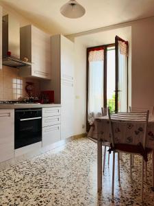 萨尔泰阿诺Claves Claustri - Appartamento storico con balcone的厨房配有桌椅和窗户。