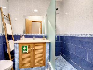 阿玛考德佩拉Mare Nostrum的浴室设有水槽、卫生间和蓝色瓷砖。